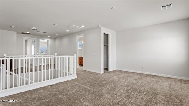 spare room featuring baseboards, visible vents, and carpet