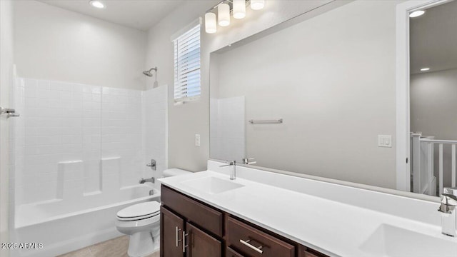 bathroom featuring shower / bathing tub combination, a sink, double vanity, and toilet