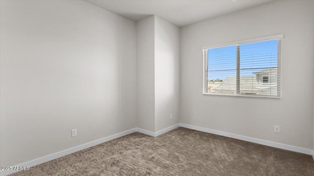 spare room with carpet and baseboards