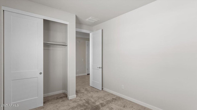 unfurnished bedroom featuring visible vents, baseboards, carpet flooring, and a closet