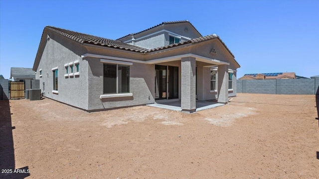 rear view of house with a tiled roof, a fenced backyard, cooling unit, a patio area, and stucco siding