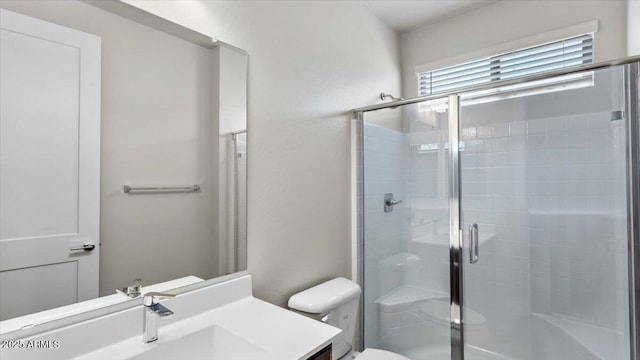 bathroom featuring vanity, toilet, and a stall shower