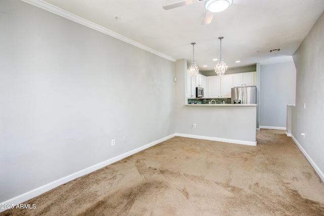 kitchen featuring appliances with stainless steel finishes, pendant lighting, white cabinets, light colored carpet, and kitchen peninsula
