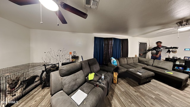 living room featuring hardwood / wood-style floors and ceiling fan