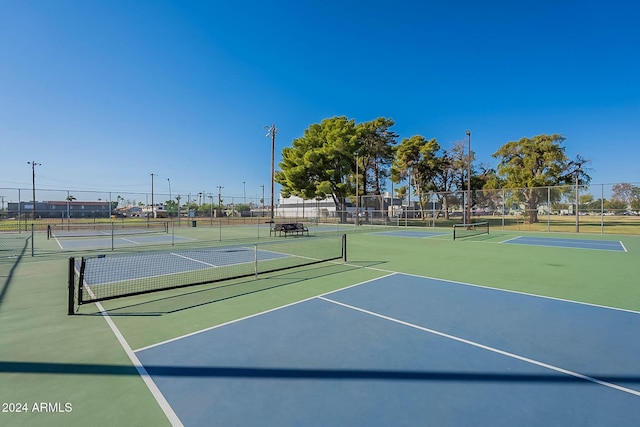 view of tennis court featuring basketball hoop