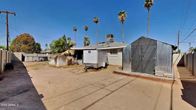 back of property featuring a storage shed