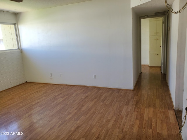 empty room with hardwood / wood-style flooring and a textured ceiling