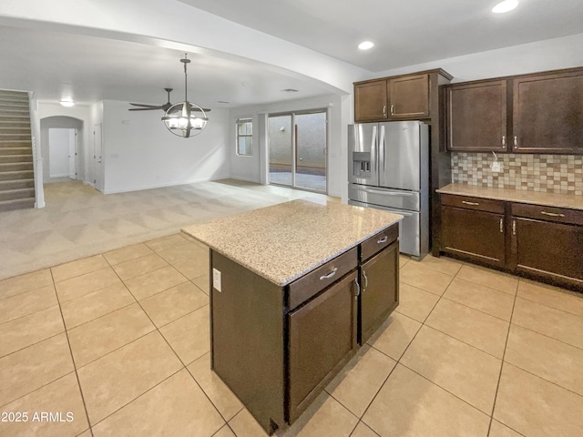 kitchen featuring a center island, light carpet, ceiling fan, tasteful backsplash, and stainless steel refrigerator with ice dispenser