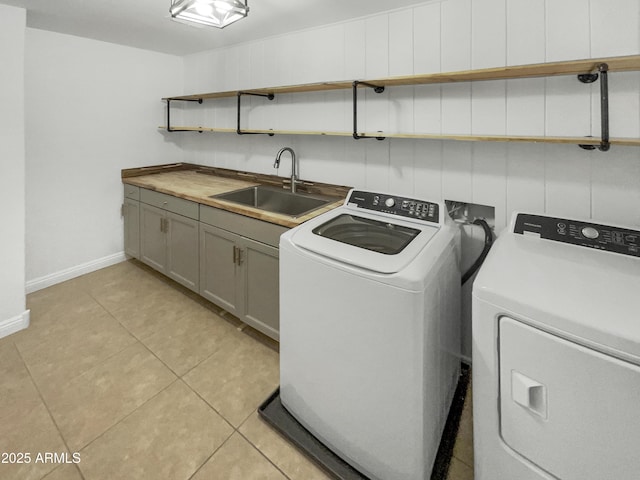 washroom with sink, washer and clothes dryer, light tile patterned flooring, and cabinets