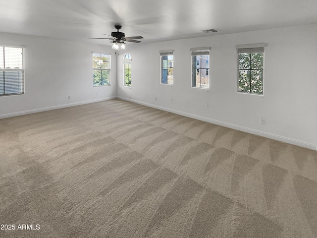 carpeted spare room with a healthy amount of sunlight and ceiling fan