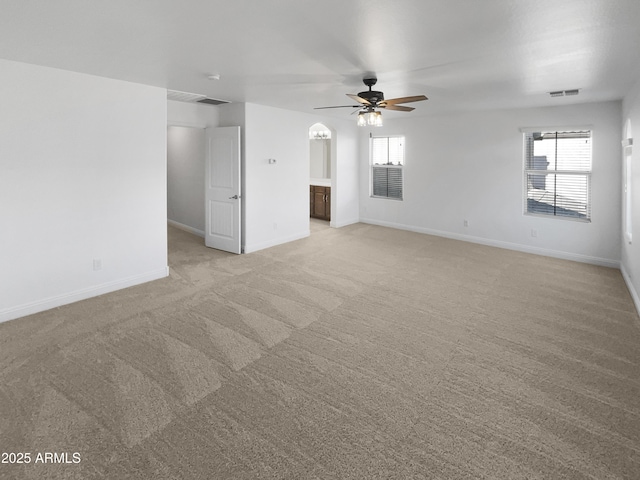 unfurnished living room with light colored carpet, ceiling fan, and plenty of natural light