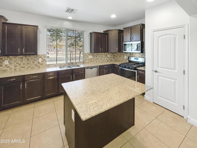 kitchen featuring sink, a center island, backsplash, and appliances with stainless steel finishes