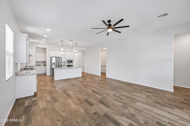 898 E Ladbroke Way, Gilbert, AZ 85297 - unfurnished living room featuring a ceiling fan, wood finished floors, recessed lighting, and baseboards