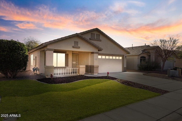 view of front of property featuring stucco siding, a front yard, a garage, and driveway