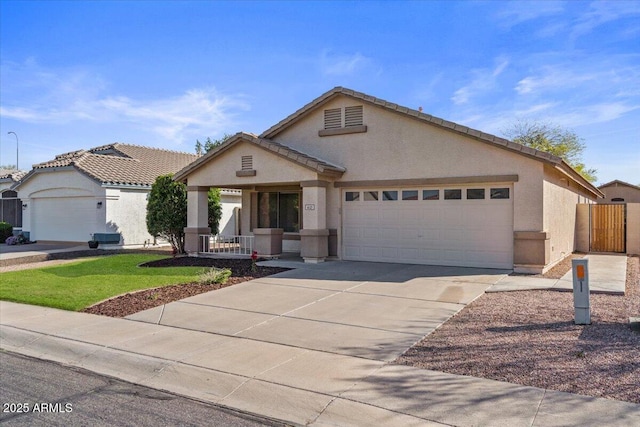 view of front of property with stucco siding, a garage, concrete driveway, and fence