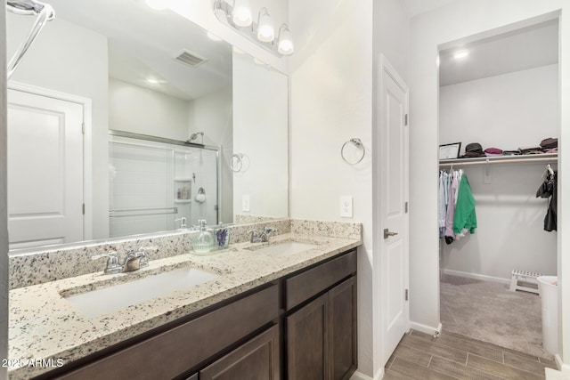 bathroom with vanity and a shower with door