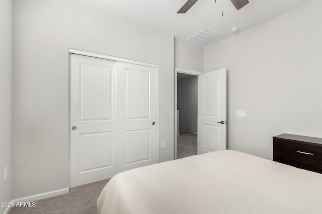 bedroom with light colored carpet, ceiling fan, and a closet