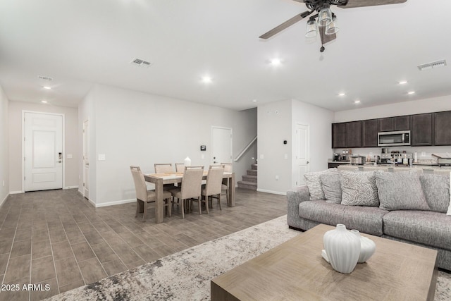 living room with light hardwood / wood-style flooring and ceiling fan