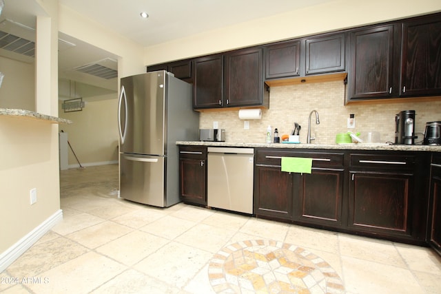 kitchen featuring backsplash, appliances with stainless steel finishes, and dark brown cabinets