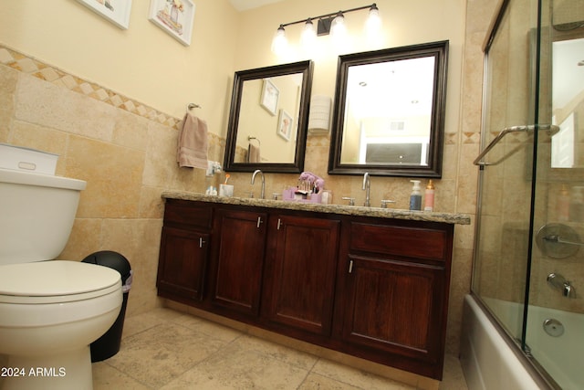 9450 N 95th St Unit 219, Scottsdale, AZ 85258 - full bathroom with tile walls, toilet, double vanity, and bath / shower combo with glass door