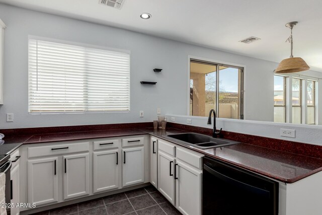 kitchen with visible vents, a sink, dishwasher, dark countertops, and dark tile patterned floors