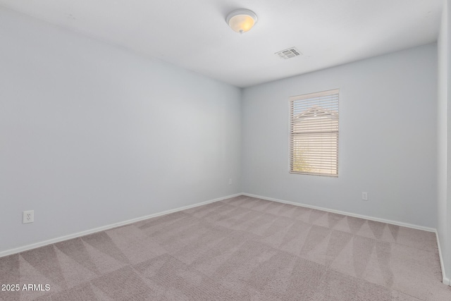 spare room with visible vents, light carpet, and baseboards