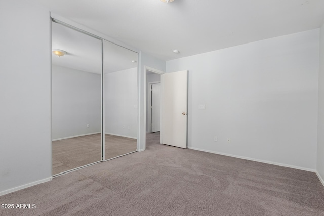 unfurnished bedroom with a closet, baseboards, and carpet