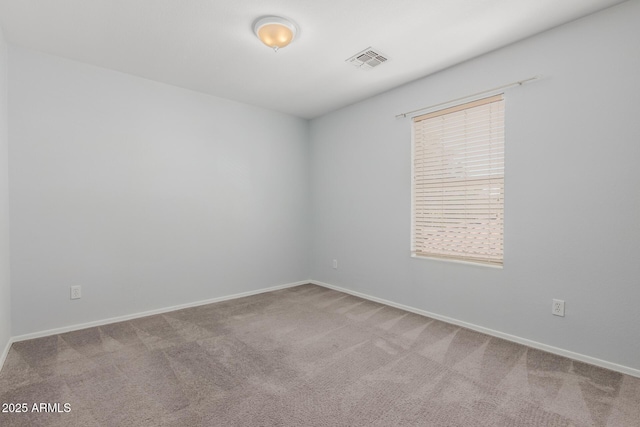 spare room featuring carpet flooring, baseboards, and visible vents