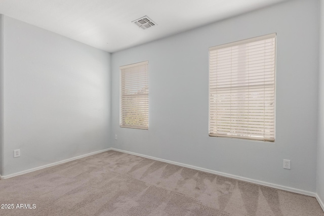 carpeted empty room with visible vents and baseboards