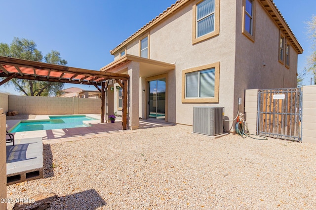 rear view of house with stucco siding, cooling unit, a fenced backyard, a patio area, and a pergola