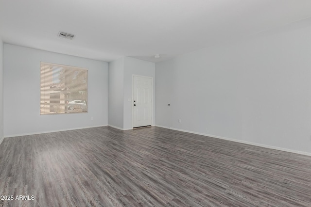 empty room with visible vents, baseboards, and wood finished floors