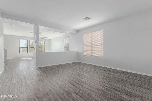 spare room with visible vents, a ceiling fan, baseboards, and wood finished floors