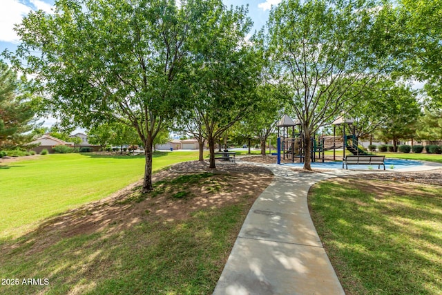 view of property's community with a lawn and playground community