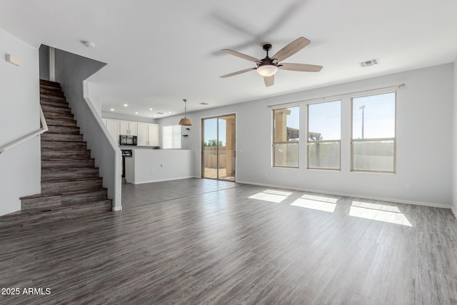 unfurnished living room with dark wood-style floors, visible vents, stairs, and baseboards