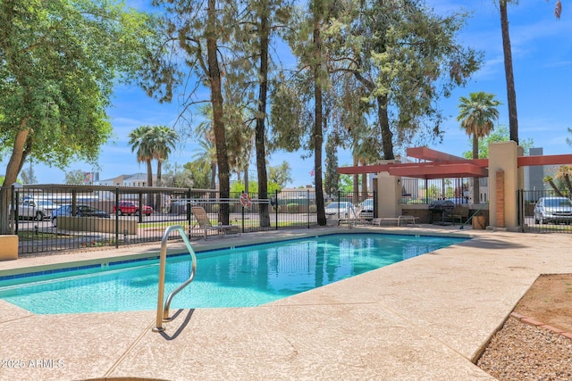 community pool with fence and a patio