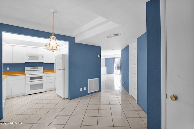 kitchen featuring white appliances, white cabinetry, light tile patterned floors, decorative light fixtures, and light countertops