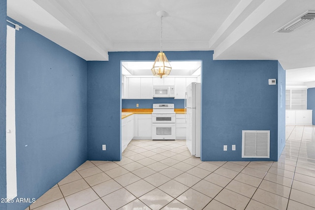 kitchen with white appliances, light tile patterned floors, white cabinets, light countertops, and hanging light fixtures