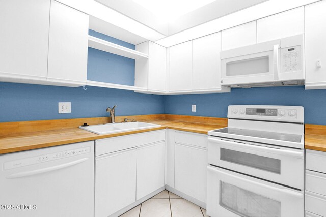 kitchen with white appliances, a sink, open shelves, wood counters, and white cabinets