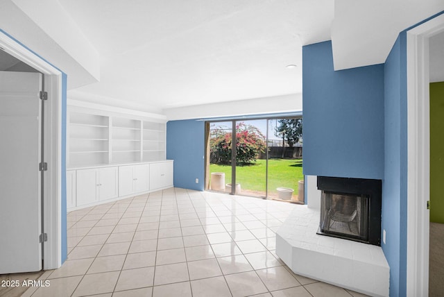 unfurnished living room with light tile patterned flooring, built in features, and a multi sided fireplace