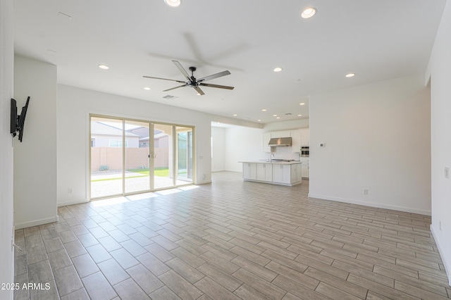 unfurnished living room featuring ceiling fan