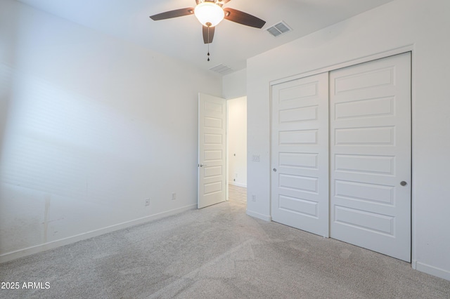 unfurnished bedroom with ceiling fan, light colored carpet, and a closet