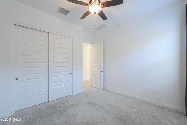 unfurnished bedroom with ceiling fan, a closet, and light carpet