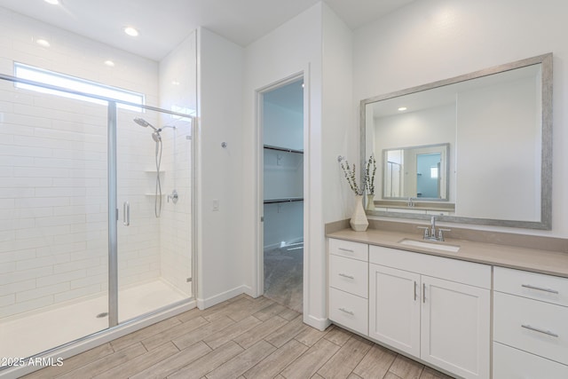 bathroom with a shower with door and vanity