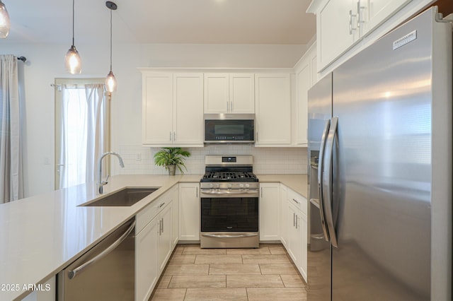 kitchen with decorative backsplash, stainless steel appliances, white cabinetry, and sink