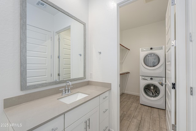 laundry area featuring stacked washer and dryer and sink