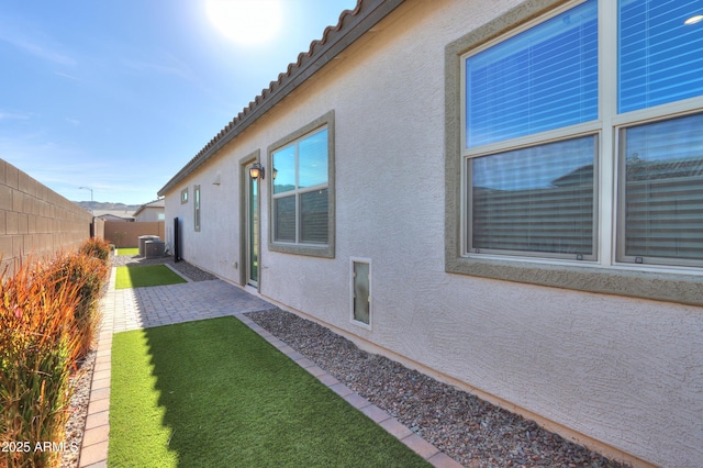 view of home's exterior featuring a lawn, central air condition unit, and a patio