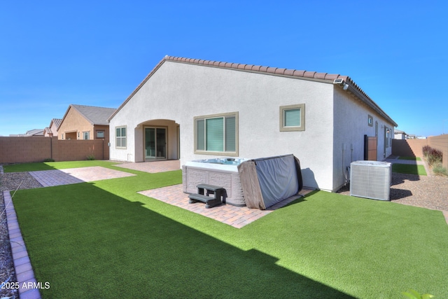 rear view of house featuring a lawn, central AC, and a patio