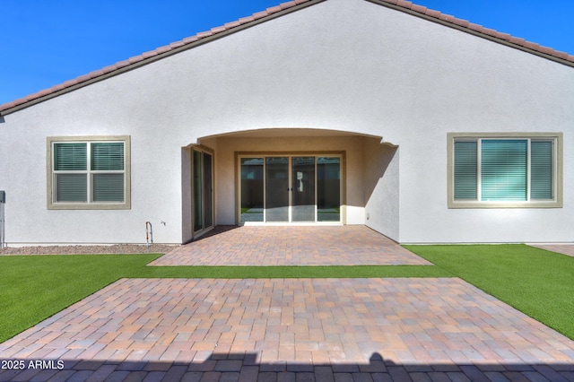 back of house featuring a lawn and a patio