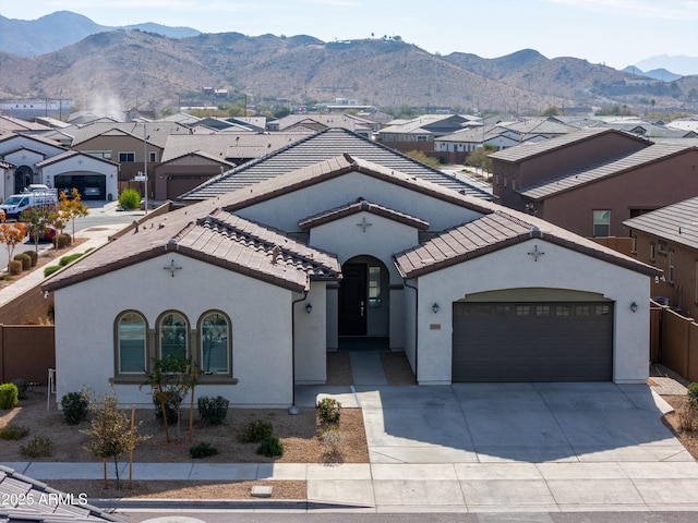 mediterranean / spanish-style home with a mountain view and a garage