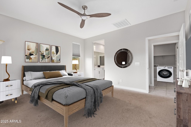 carpeted bedroom featuring washer / dryer, ceiling fan, and ensuite bathroom